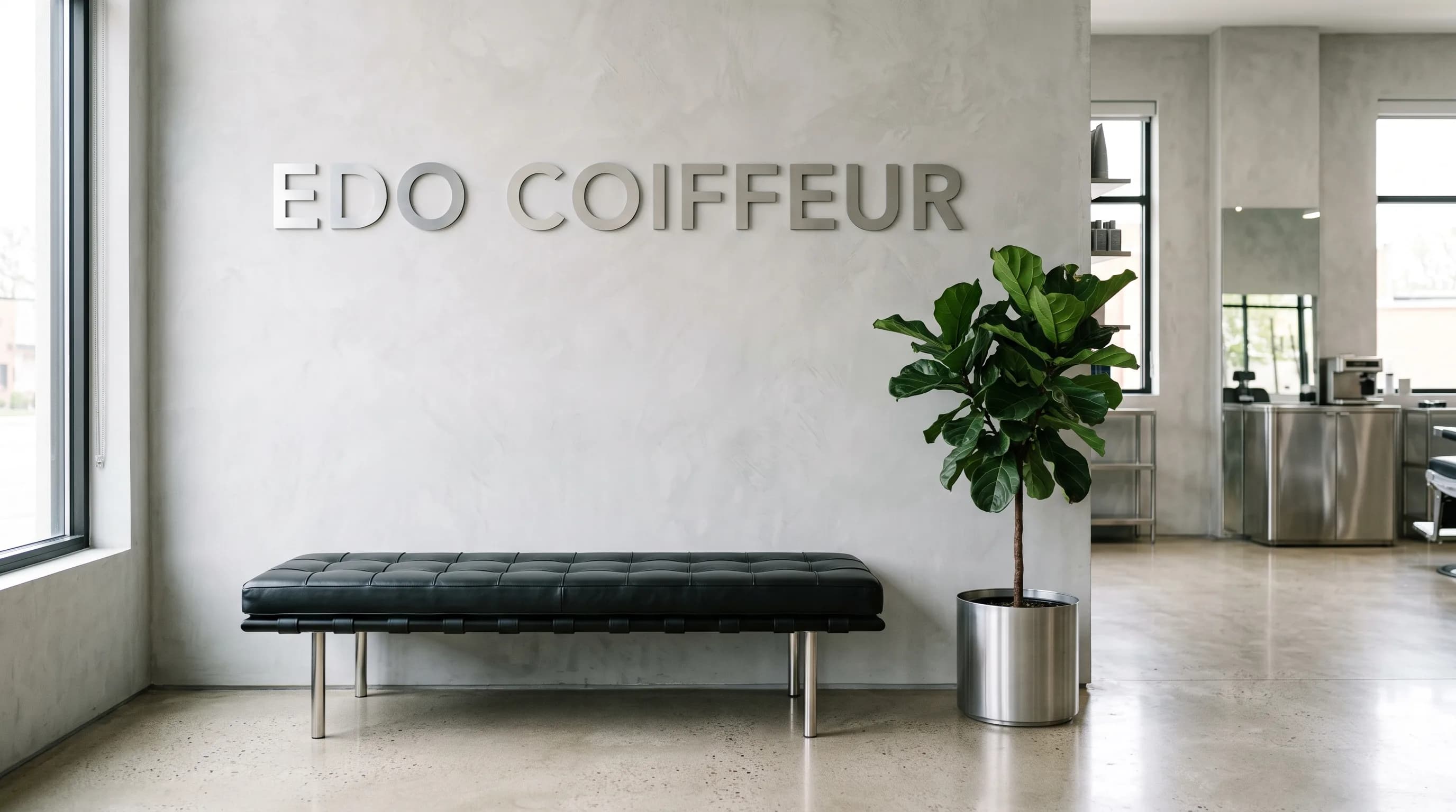 Eingangsbereich in Basel mit dem Schriftzug Edo Coiffeur auf grauer Wand
